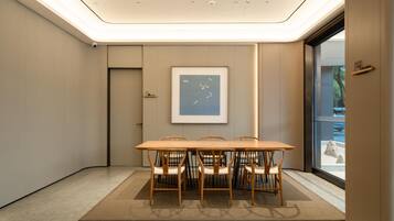 Uma sala de conferência moderna com uma mesa comprida e cadeiras, uma obra de arte emoldurada na parede e vista através de uma porta de vidro.