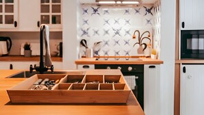 A modern kitchen with white cabinets, a wooden countertop, and a backsplash with a star pattern.