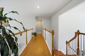 A wooden staircase with white railings leading to a landing.
