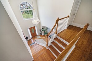 Un escalier en bois avec des rampes blanches menant à un palier.