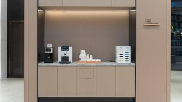 Een moderne koffiehoek met een koffieapparaat, een waterdispenser en een koffiemachine.