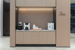 En moderne kaffestation med kaffemaskine, vanddispenser og kaffebrygger.