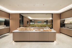 A modern kitchen with a central island, built-in appliances, and a sleek design. - Ji Hotel Guangzhou Panyu Chimelong Wanbo (Guangzhou)