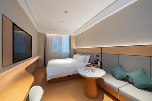 A modern hotel room with a bed, a desk, a sofa, and a TV. - Ji Hotel Guangzhou Panyu Chimelong Wanbo (Guangzhou)