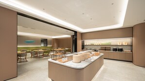 A modern hotel lobby with a central island, seating area, and a kitchen counter with amenities. - Ji Hotel Guangzhou Panyu Chimelong Wanbo (Guangzhou)