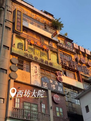 A multi-story building with various signs and advertisements. - Ji Hotel Guangzhou Panyu Shiqiao Metro Station (Guangzhou)