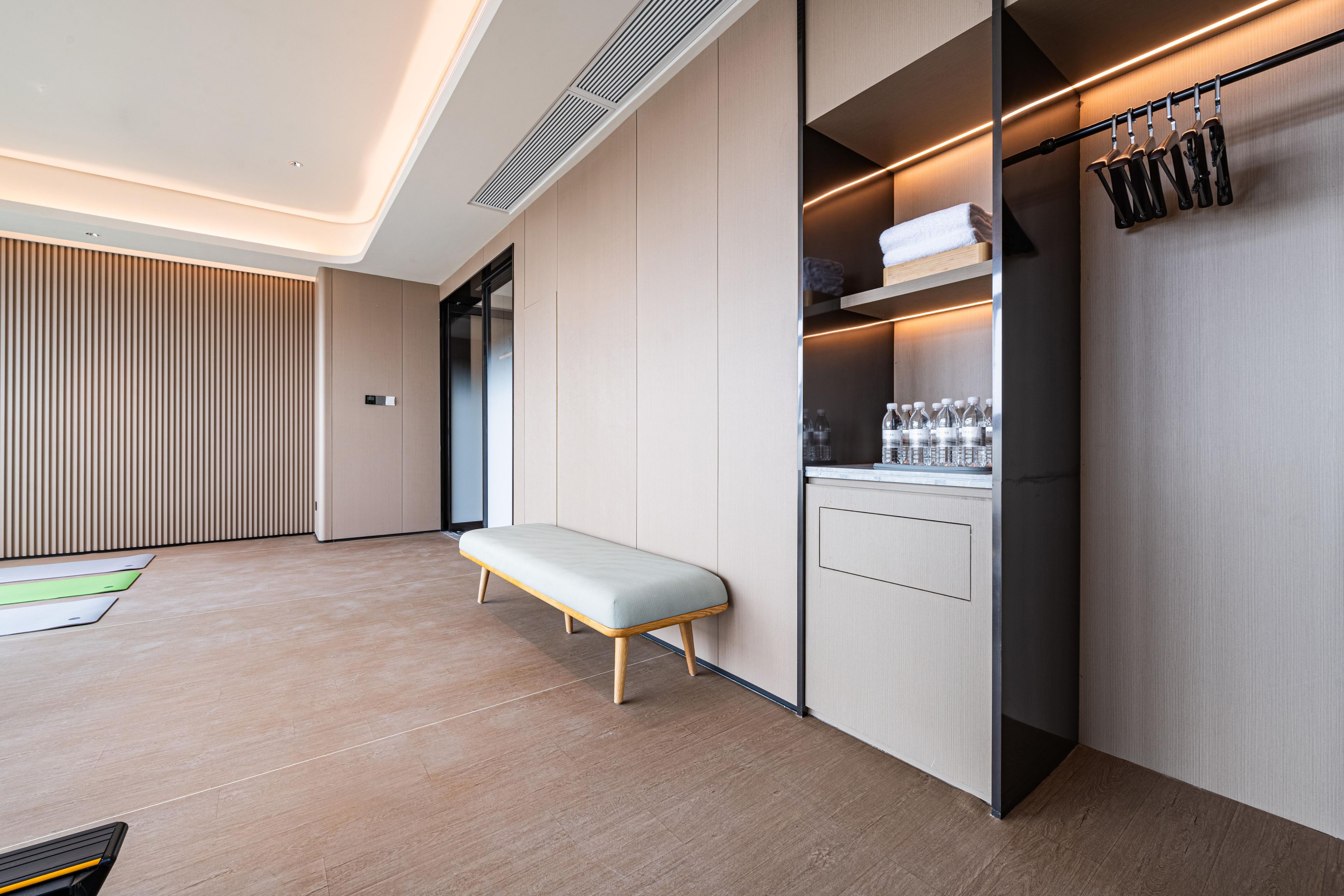 A modern kitchen with a bench, built-in appliances, and a hanging rack.