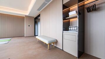 A modern kitchen with a bench, built-in appliances, and a hanging rack.
