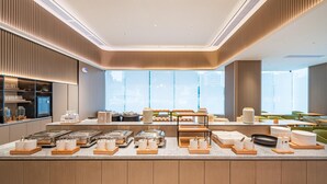 Un área de desayuno buffet moderna con una variedad de alimentos y utensilios organizados cuidadosamente en bandejas de madera.