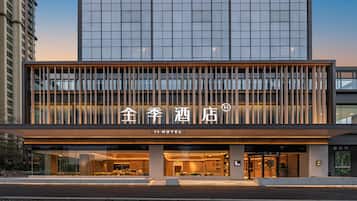 A modern hotel with a glass facade, a prominent entrance, and signage in a foreign language.