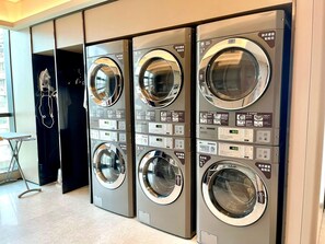 A row of three front-loading washing machines in a commercial setting. - Ji Hotel Guangzhou Panyu Shiqiao Metro Station (Guangzhou)