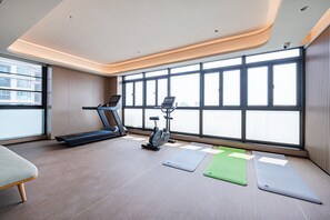 A modern gym with a treadmill, stationary bike, and yoga mats. - Ji Hotel Guangzhou Panyu Shiqiao Metro Station (Guangzhou)