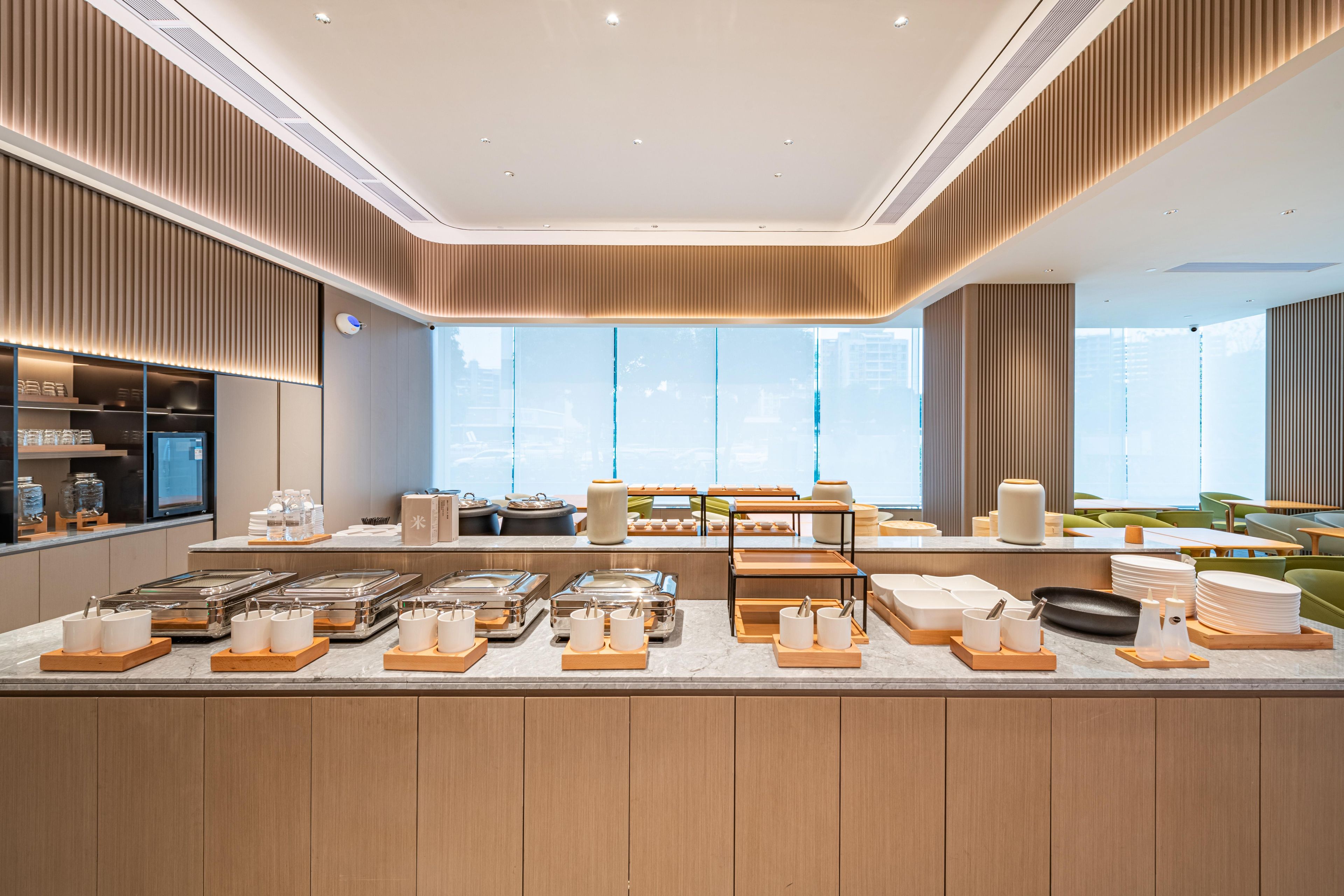 Een modern ontbijtbuffet met diverse gerechten en bestek, netjes gepresenteerd op houten dienbladen.