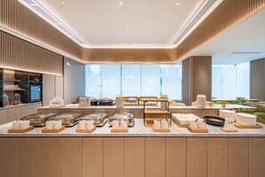 A modern breakfast buffet area with a variety of food items and utensils neatly arranged on wooden trays. - Ji Hotel Guangzhou Panyu Shiqiao Metro Station (Guangzhou)