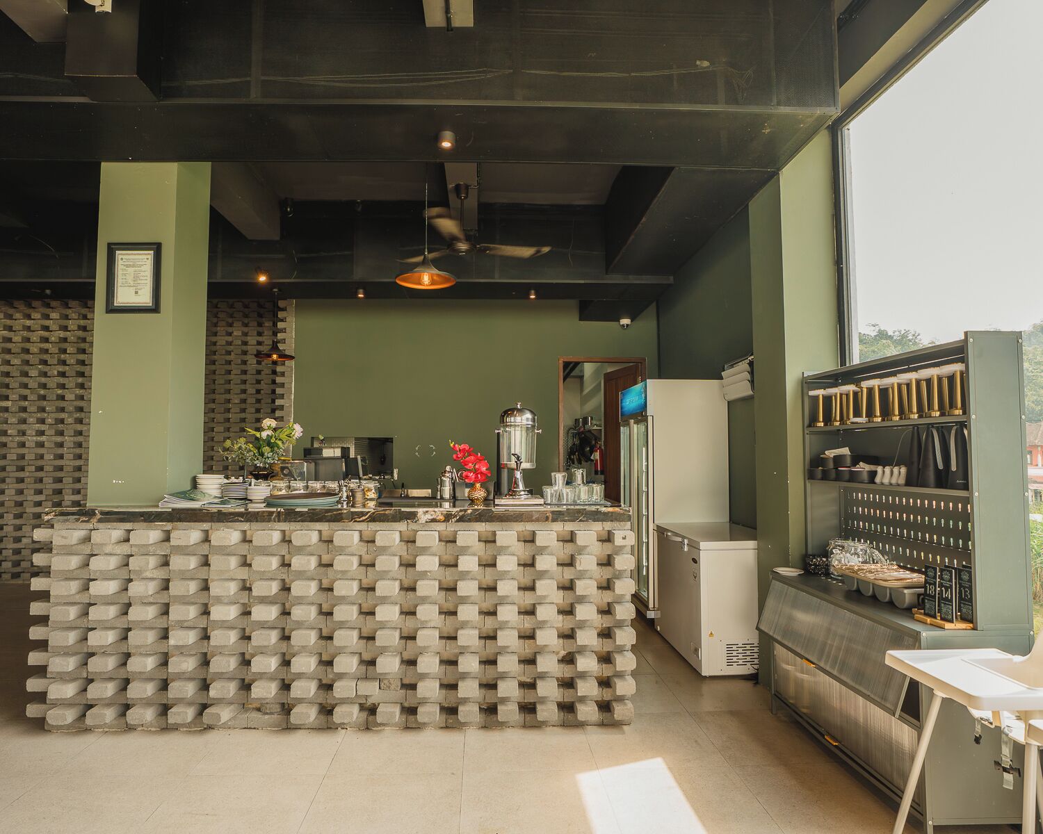 A bar area with a brick counter, a ceiling fan, and a view of the outside.