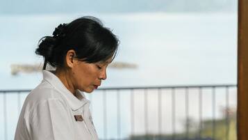 A person receiving a massage in a room with a view of a body of water and mountains.