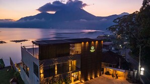A modern building with a flat roof, large windows, and a well-lit entrance. - Tribhuwana Padma Lake Resort (Kintamani)