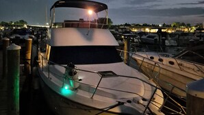 A boat docked at a marina with a covered deck and a spotlight. - TROPICAL WATERFRONT/POOL  BEACH, BOAT🛥 HOME BY VENICE SIESTA KEYS BEACH PETS OK (Port Charlotte)