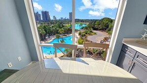 Ein Zimmer mit großem Fenster mit Blick auf einen Pool und die Skyline der Stadt.
