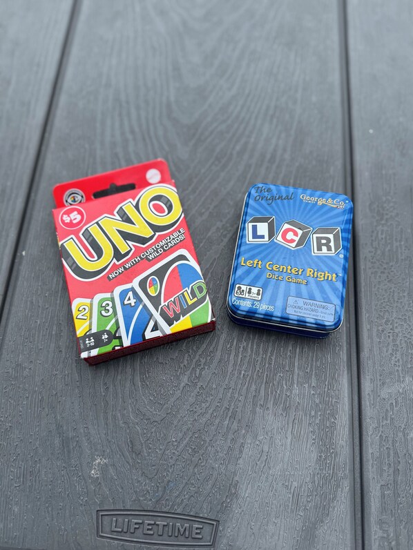 Two game boxes, UNO and Left Center Right, on a wooden surface.