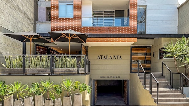 A modern building with a sign reading "ATALANTA" and a staircase leading to an entrance.