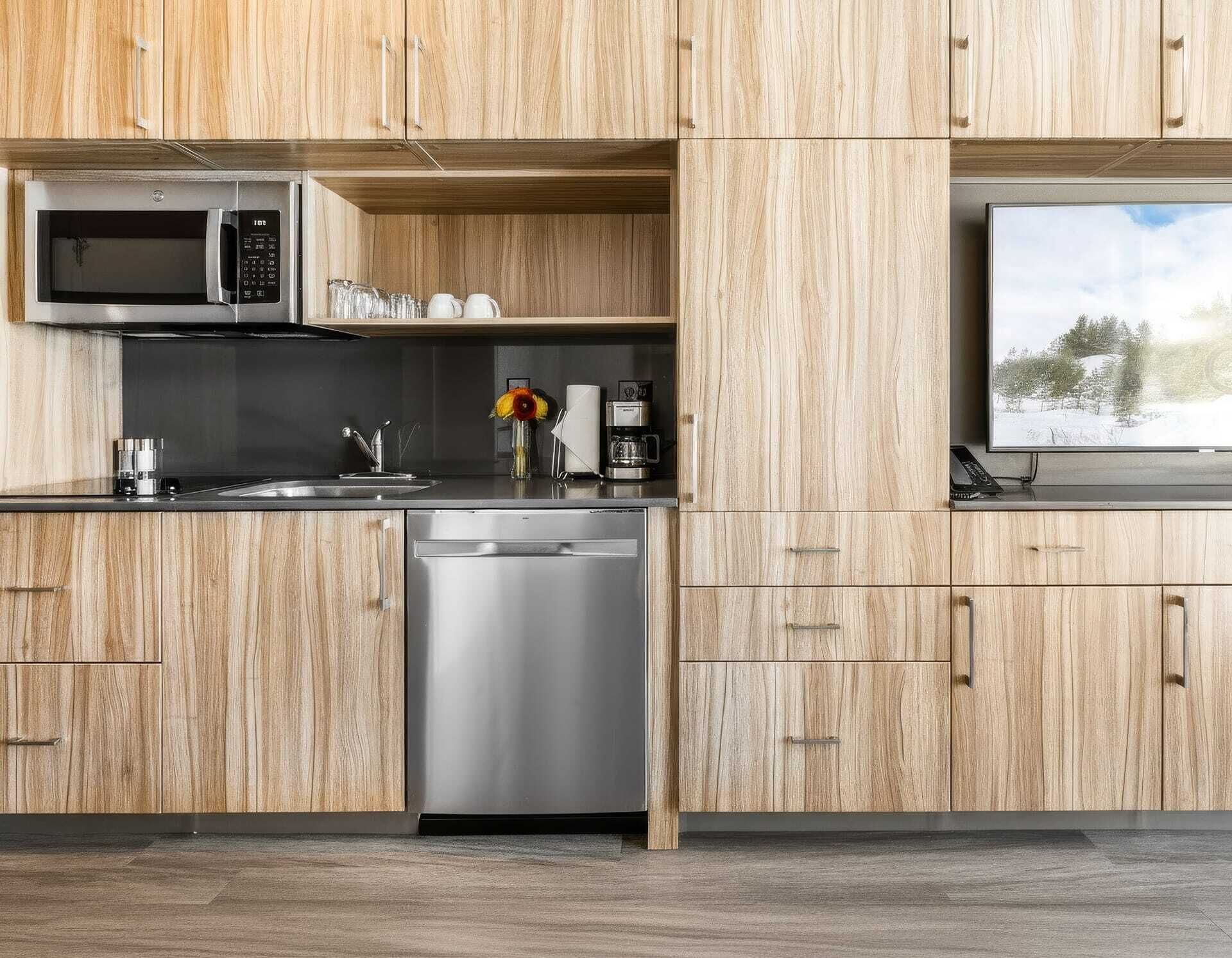 A modern kitchen with wooden cabinets, stainless steel appliances, and a built-in TV.