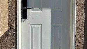 A white door with a black mailbox and a house number sign. - Cozy 1-BR Suite in West Side • Kitchen & Living (Vancouver)