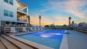 A swimming pool with lounge chairs and a wooden deck. - Huge Private Pool | Firepit | Beach One Block Away (gulf shores)