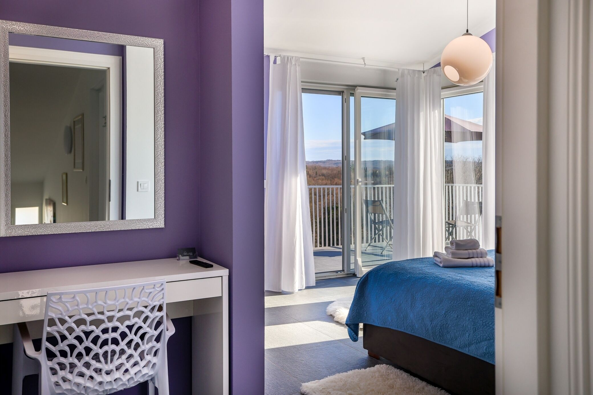 A bedroom with a bed, a desk, and a chair.