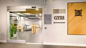 A gym entrance with a glass door, treadmill, and exercise equipment. - Penthouse with Ocean view from the upper balcony - B314 North Coast Village (Oceanside)
