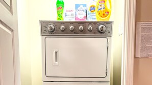 A compact washer and dryer unit with a control panel and detergent bottles on top.