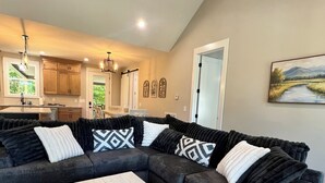 A modern living room with a sectional sofa, a wooden coffee table, and a patterned rug. - Peaceful Hilltop Lake Retreat (Lynchburg)
