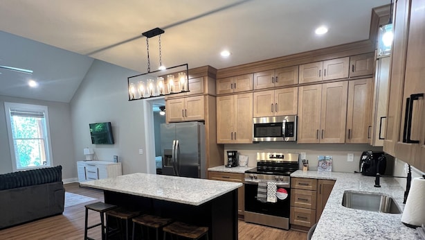 A modern kitchen with granite countertops, stainless steel appliances, and wooden cabinetry. - Peaceful Hilltop Lake Retreat (Lynchburg)