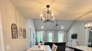 A spacious kitchen with a dining area, wooden flooring, and a modern chandelier. - Peaceful Hilltop Lake Retreat (Lynchburg)