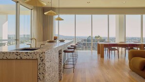 A modern kitchen with a large island, bar stools, and a dining area with a table and chairs.