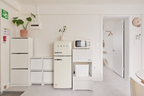 Uma cozinha compacta equipada com geladeira, micro-ondas e um pequeno armário.