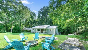 A backyard with a house, green lawn, and outdoor seating area with Adirondack chairs and a fire pit. - Lookout Mtn. Escape w/ Fire Pit & 1 Acre Level Lawn- Mins to Cloudland Canyon (Rising Fawn)