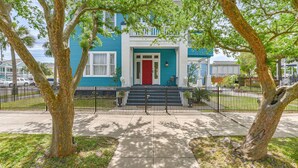 A two-story house with a red door and a blue exterior. - Cozy 2nd-Floor Suite near Beach, The Strand, Pier (Galveston)