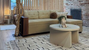 Un salon moderne avec un canapé, une table basse et une plante décorative.