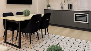 Une cuisine moderne avec un coin repas, comprenant un téléviseur à écran plat, un évier et un four.