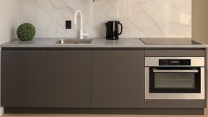 Une cuisine moderne équipée d’un four encastré, d’un évier et d’une machine à café.