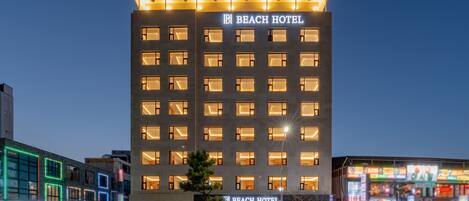 Ein mehrgeschossiges Hotel mit einem auffälligen Schild, auf dem "BEACH HOTEL" steht.