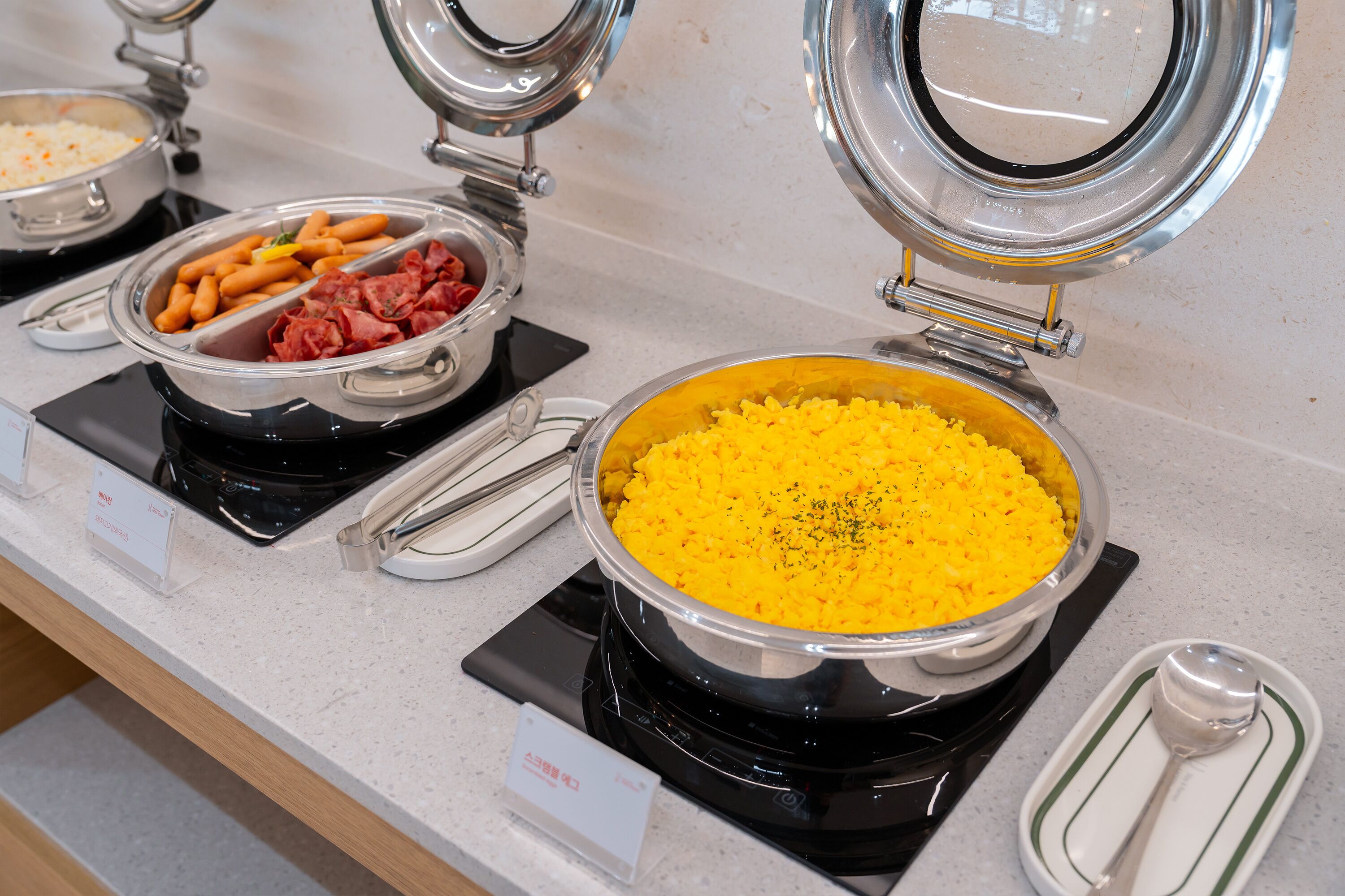 A buffet with various food items including rice, sausages, and meat.