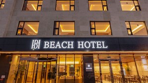Un hotel de varios pisos con un cartel llamativo que dice "Beach Hotel".