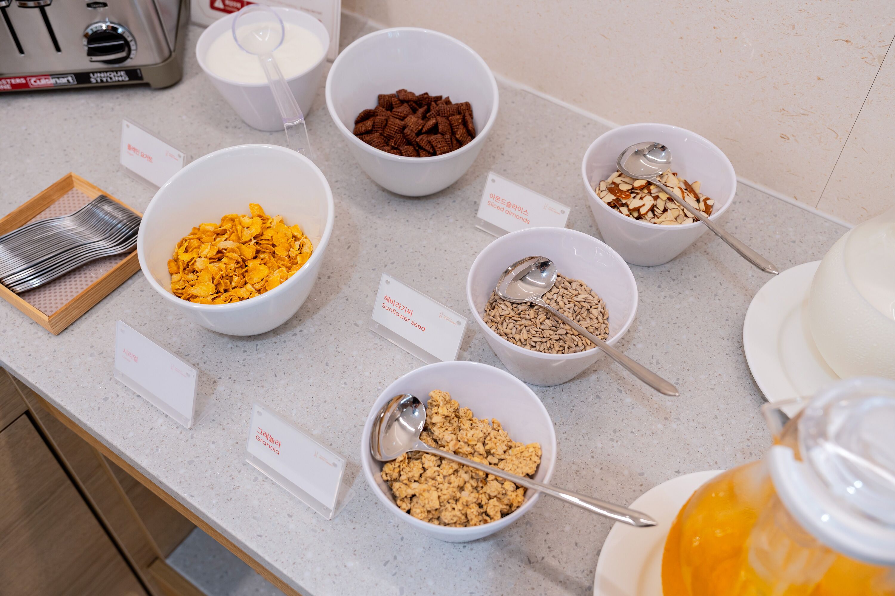 Ein Frühstücksbuffet mit verschiedenen Müslisorten und Besteck.
