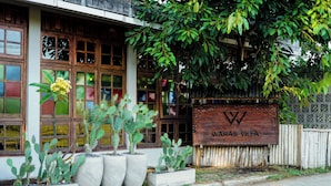 A building with a sign reading "WARAS VILLA" and large potted cacti in front. - Waras Villa (Gili Trawangan)