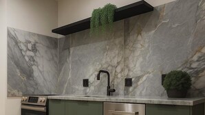 Una cocina moderna con horno empotrado, lavavajillas de acero inoxidable y salpicadero de mármol.
