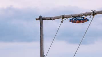 A wooden swing structure with a sign reading "Welcome to Gua Daibach".