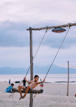 A wooden swing structure with a sign reading "Welcome to Gua Daibach". - CocoPalm Hoi An River Beach By JM Villas (Hoi An)