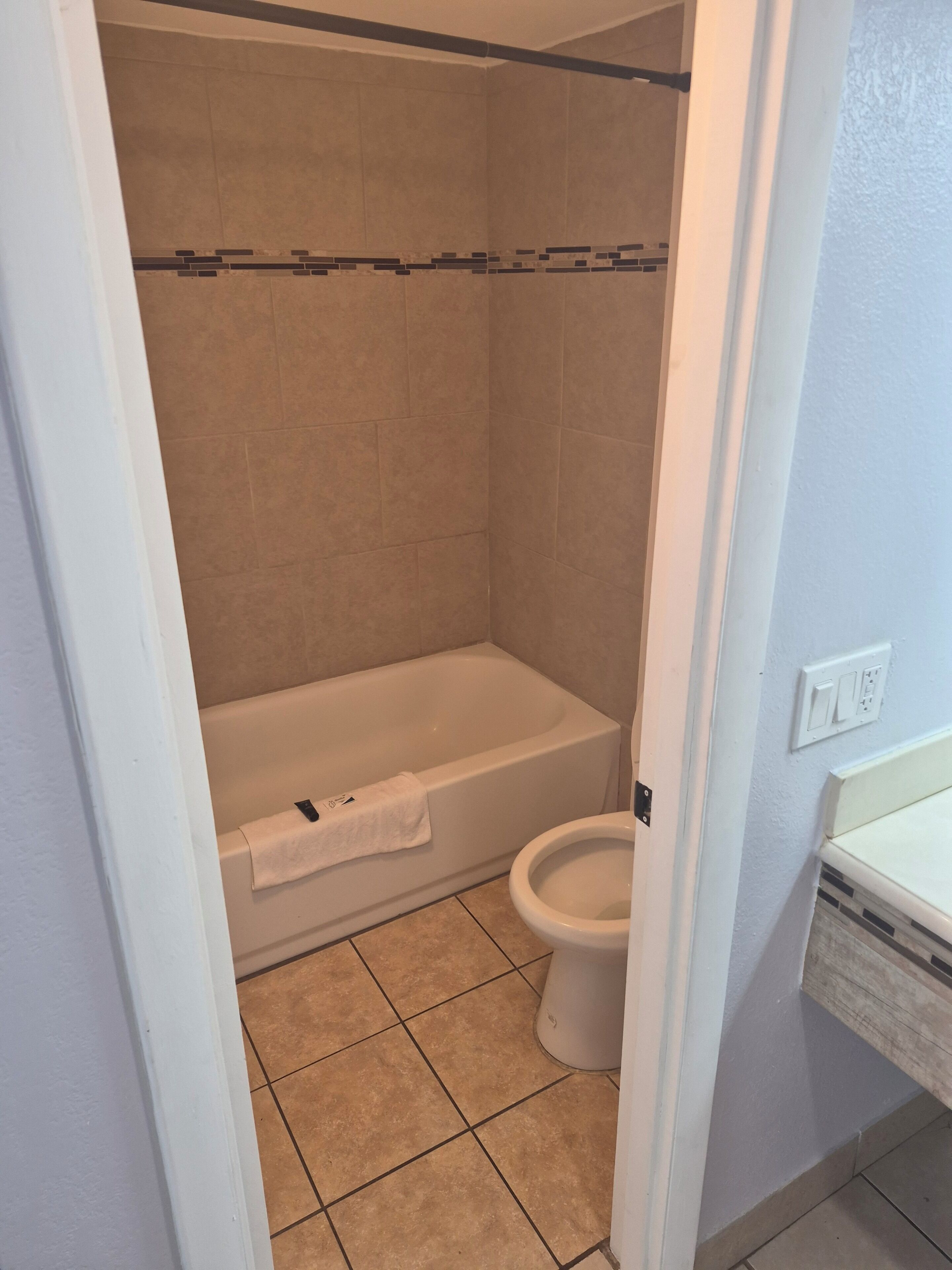 シャワー付き浴槽、タオル、石鹸、トイレットペーパー